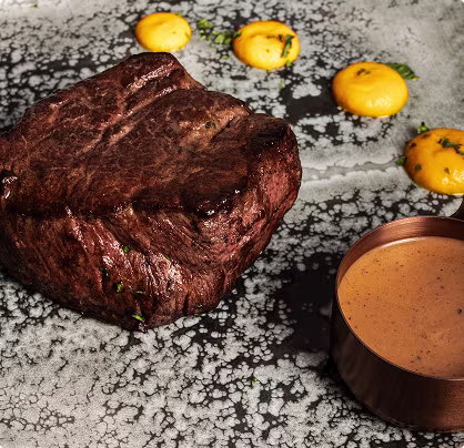 Mesa con comida y bebida en Hi-Life Steak House Puerto Calero