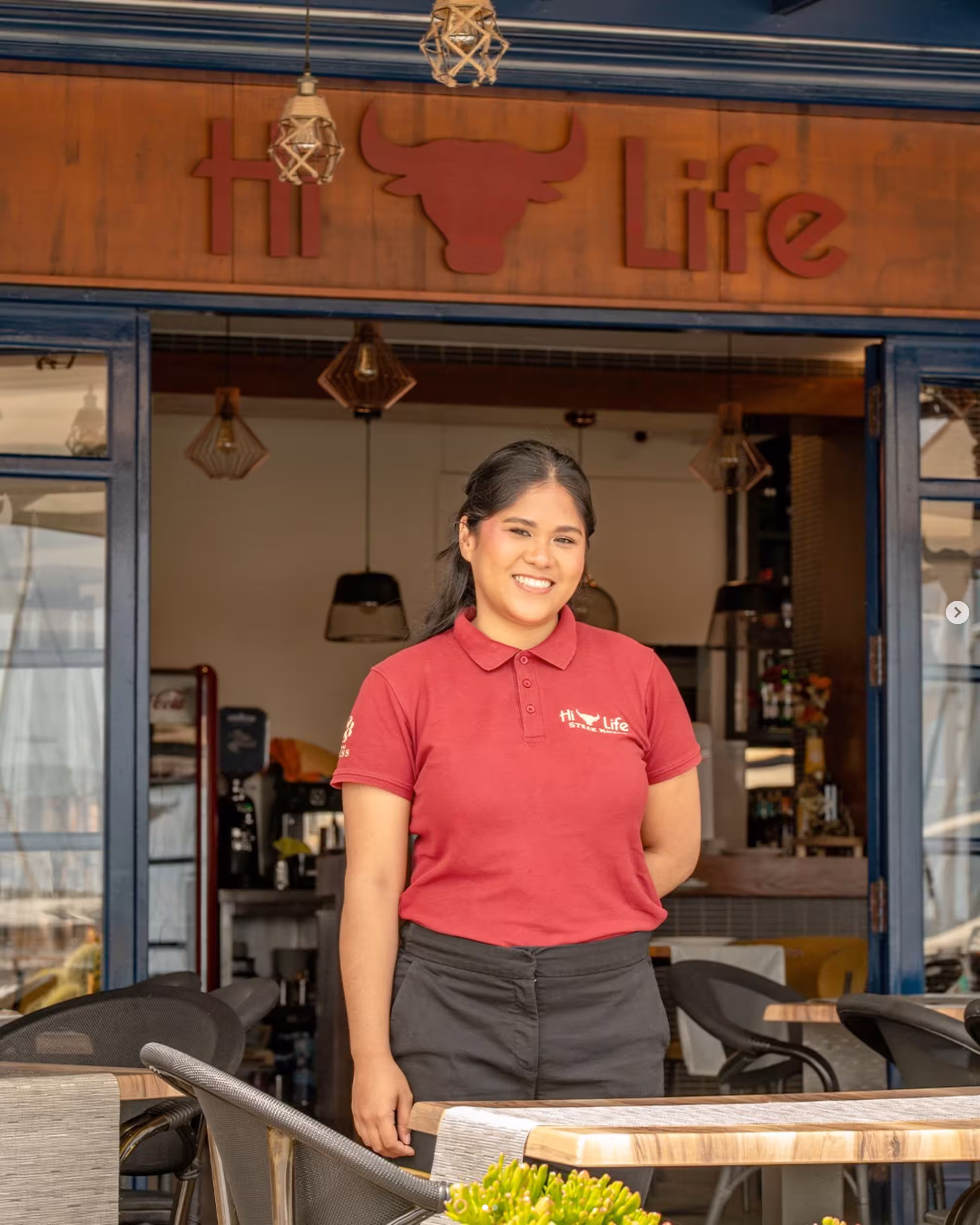 Camarera profesional atendiendo a los clientes en el elegante ambiente de Hi-Life Steak House